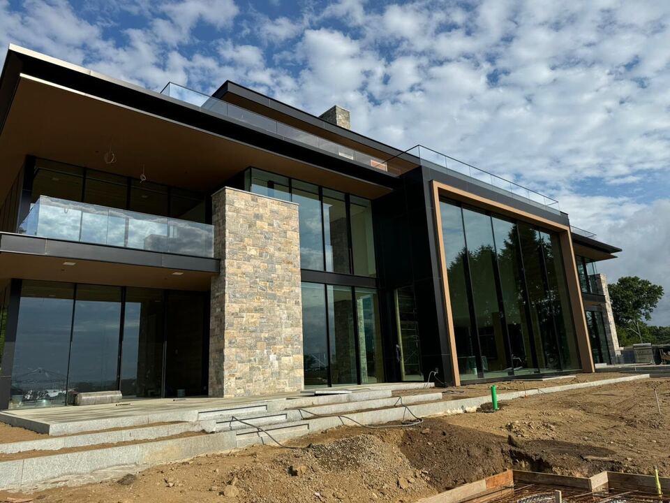 Stone and glass modern home with black-framed windows