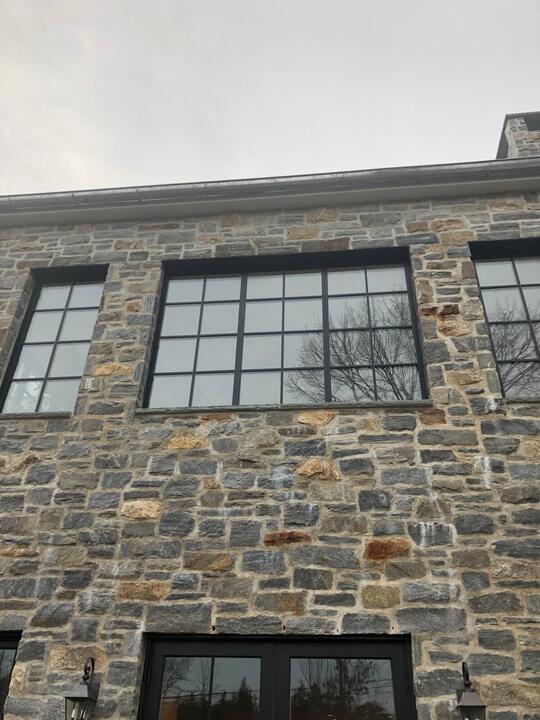 Black grid windows set into a stone wall