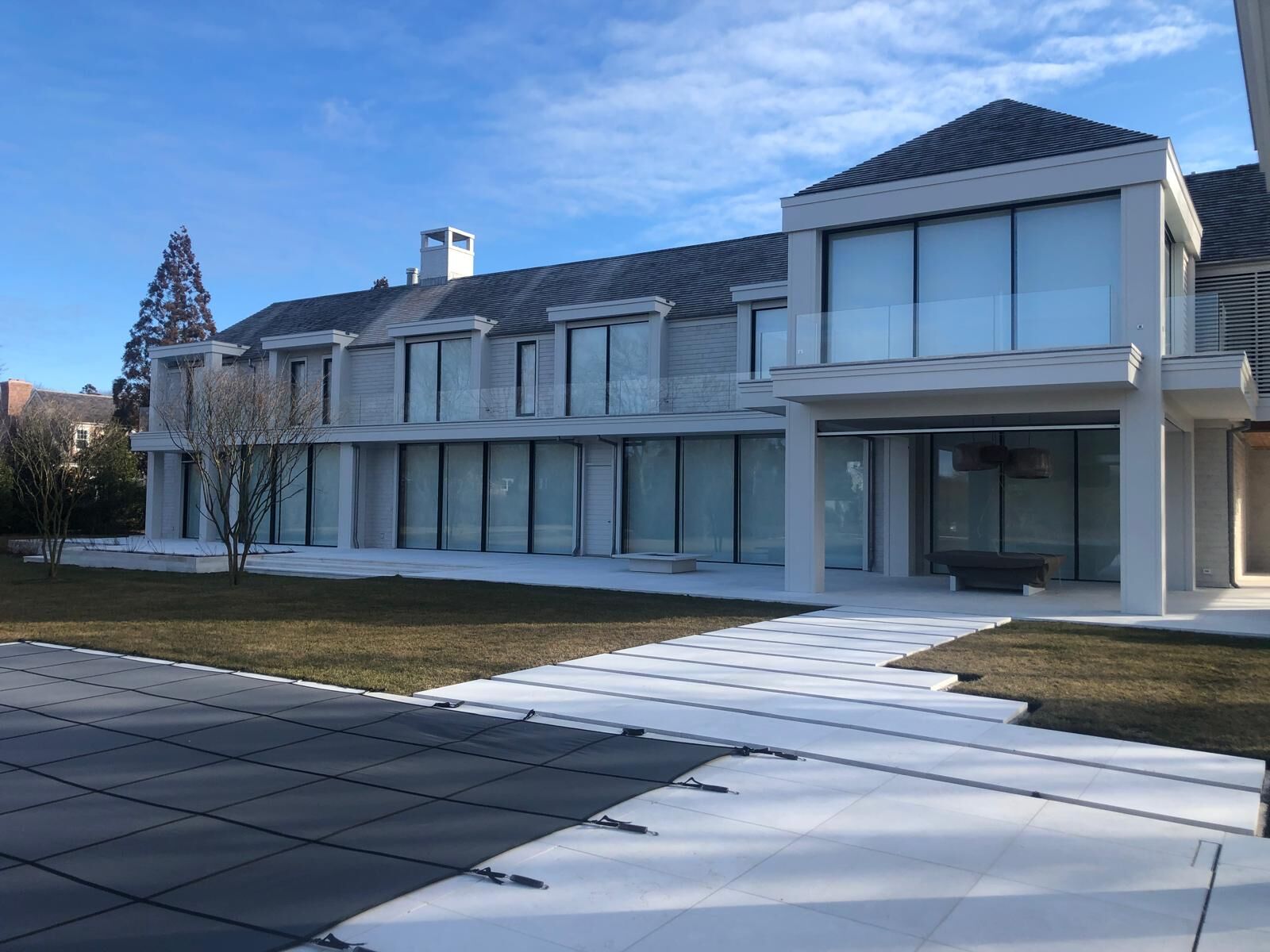 Contemporary home with window walls and a glass balcony railing
