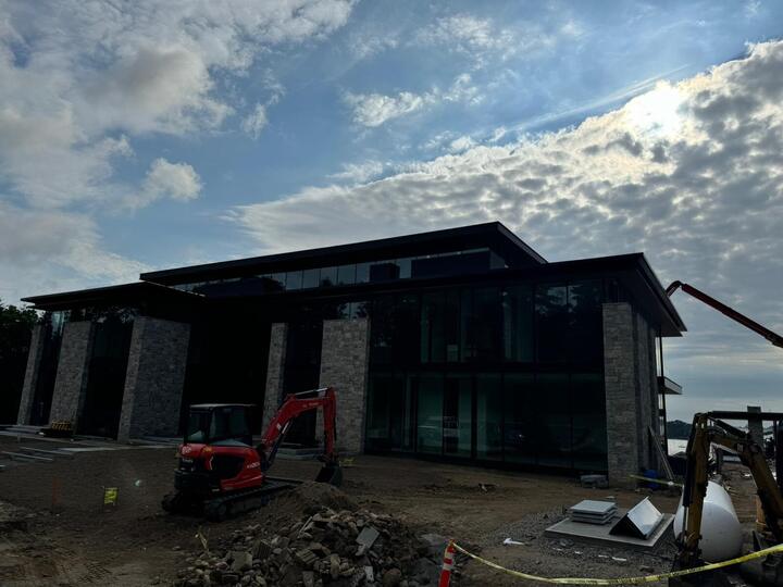 Dark modern home with glass walls under construction
