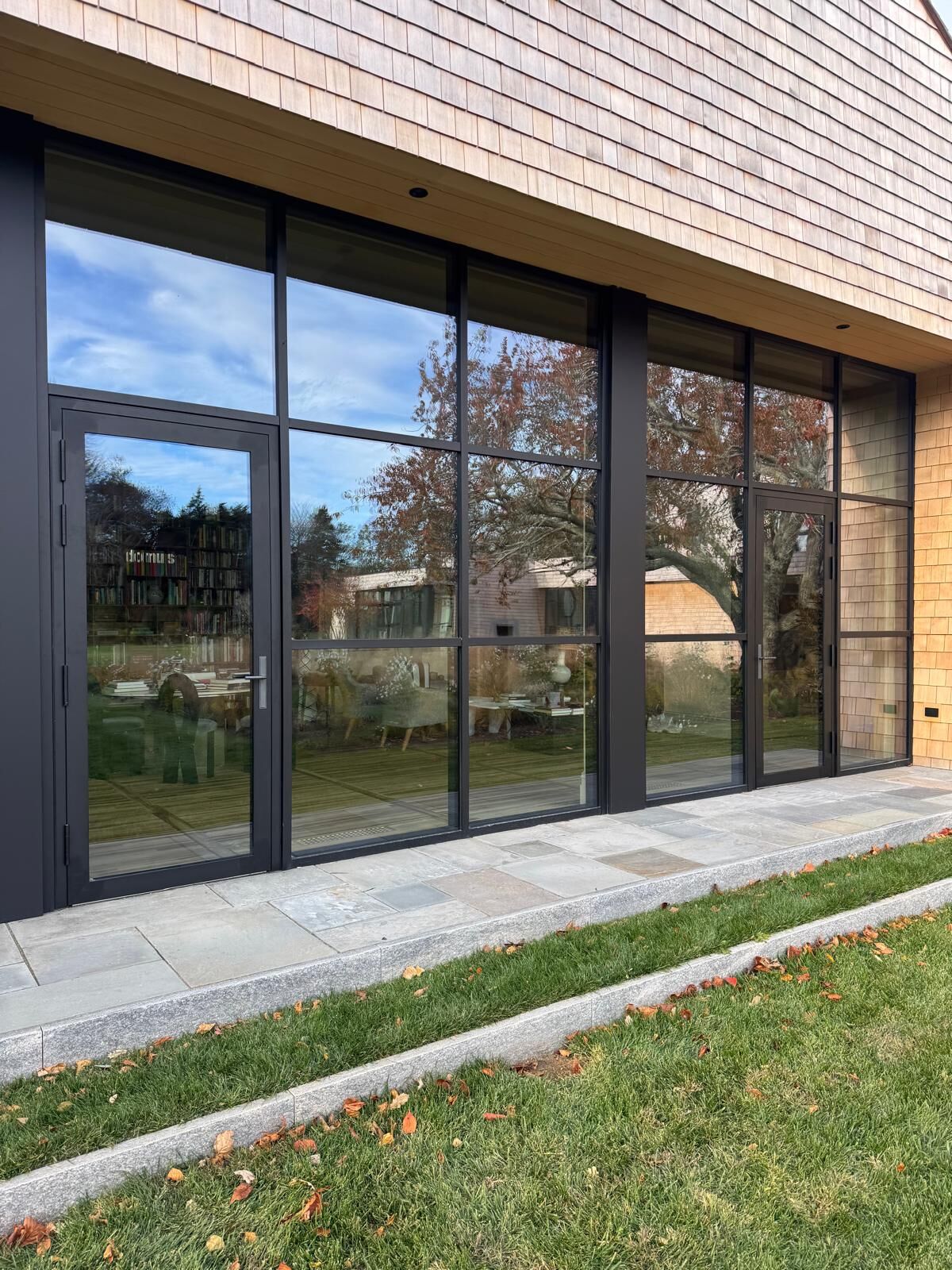 Black steel-look glass wall and entry door on a new home